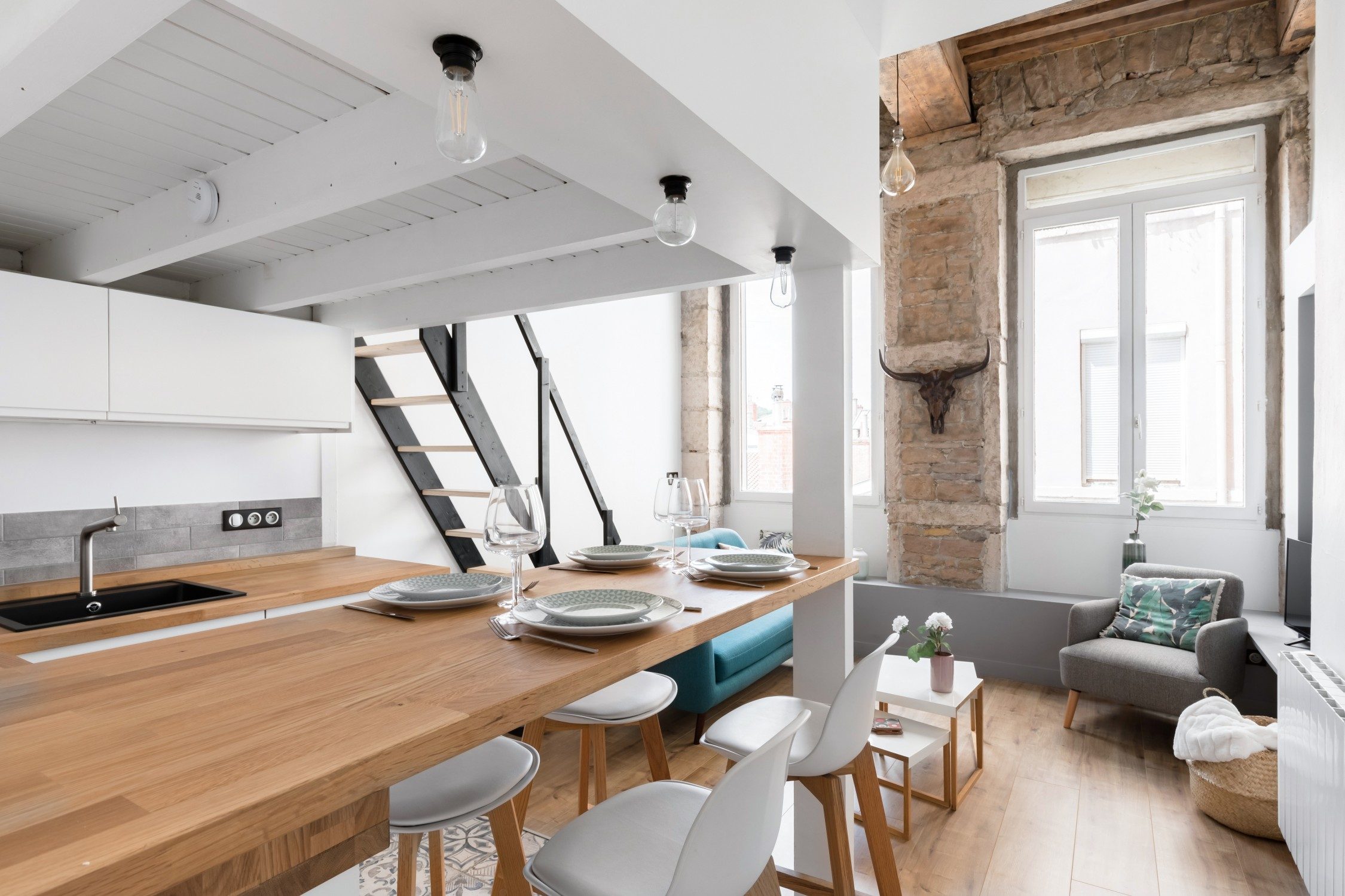 Réalisation CozyNest Réno à la Croix-Rousse : cuisine ouverte, mezzanine et pierres apparentes